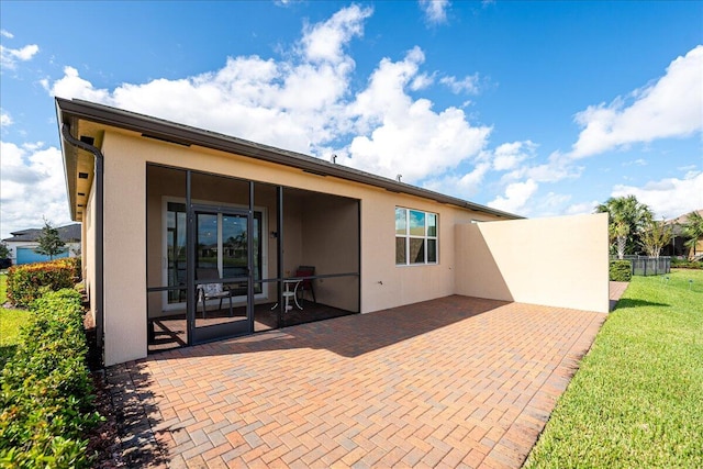 back of house with a lawn and a patio