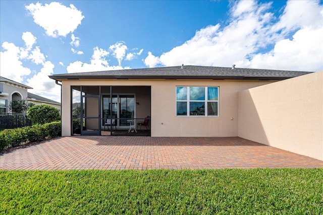 rear view of property with a sunroom and a patio