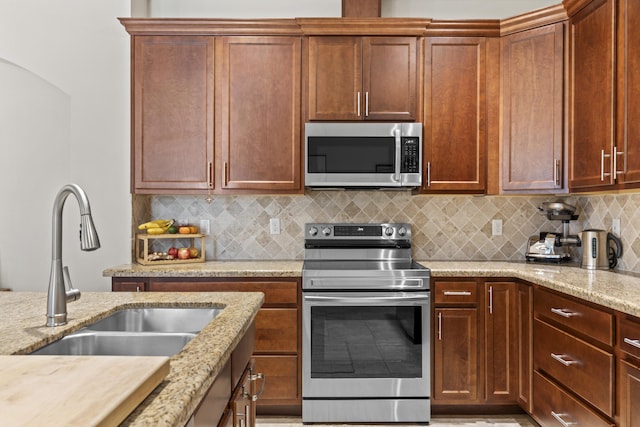 11507 SW Lake Park Dr, Port Saint Lucie, FL 34987 - kitchen featuring appliances with stainless steel finishes, a sink, tasteful backsplash, and light stone countertops