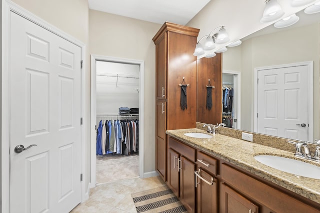 11507 SW Lake Park Dr, Port Saint Lucie, FL 34987 - bathroom with double vanity, a walk in closet, tile patterned floors, and baseboards