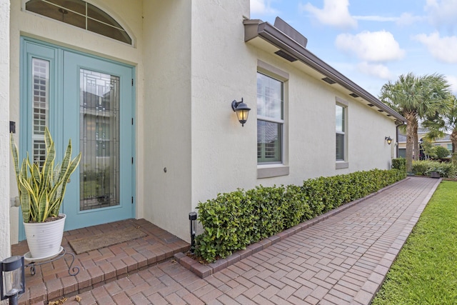 entrance to property featuring stucco siding