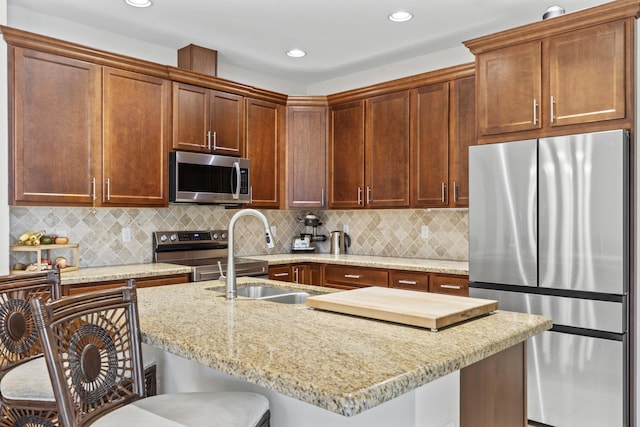 11507 SW Lake Park Dr, Port Saint Lucie, FL 34987 - kitchen with stainless steel appliances, a kitchen breakfast bar, a sink, light stone countertops, and recessed lighting
