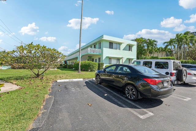 view of parking / parking lot featuring a yard