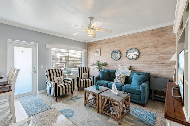 living room featuring ceiling fan, ornamental molding, and wooden walls