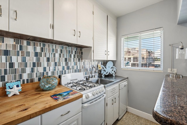 kitchen featuring kitchen peninsula, backsplash, gas range gas stove, a breakfast bar, and white cabinetry