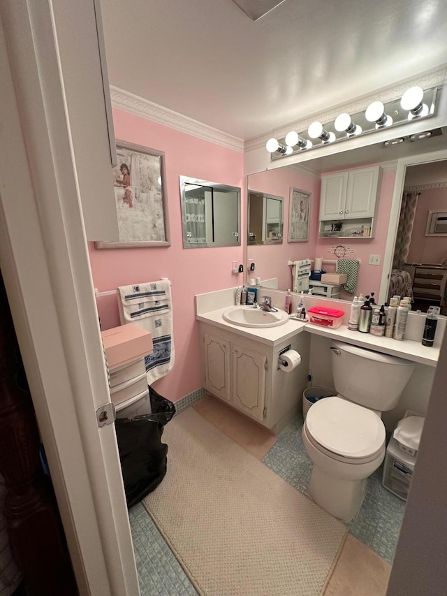 bathroom with tile patterned floors, toilet, vanity, and ornamental molding