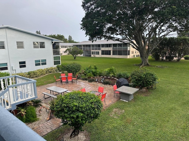 view of yard featuring a sunroom, a deck, and a patio