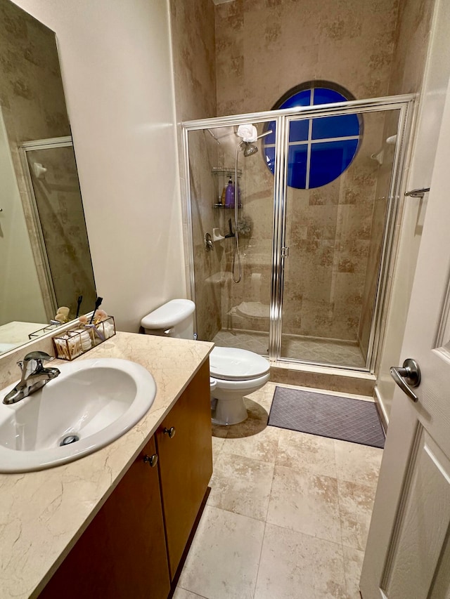 bathroom with vanity, toilet, and a shower with shower door