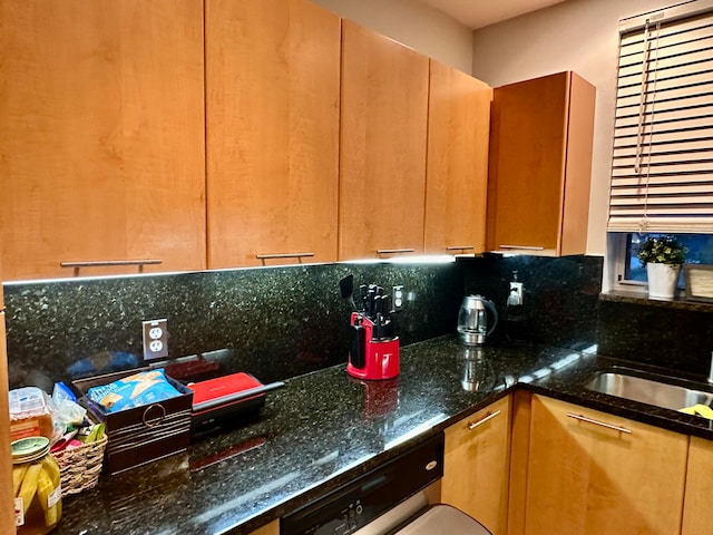 kitchen with decorative backsplash, dark stone counters, and sink