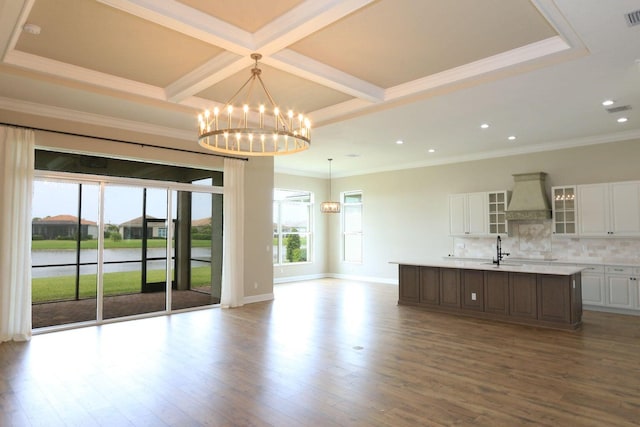 interior space with sink, coffered ceiling, an inviting chandelier, crown molding, and wood-type flooring