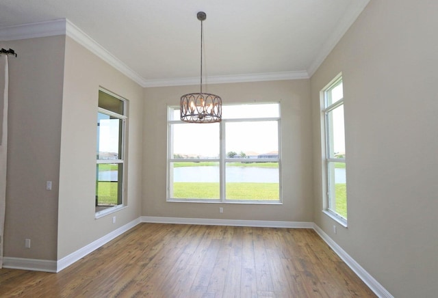 unfurnished room with wood-type flooring, a water view, an inviting chandelier, and ornamental molding