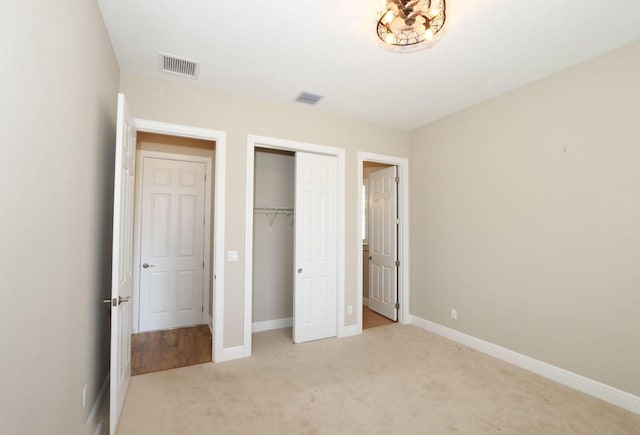 unfurnished bedroom with light colored carpet and a closet