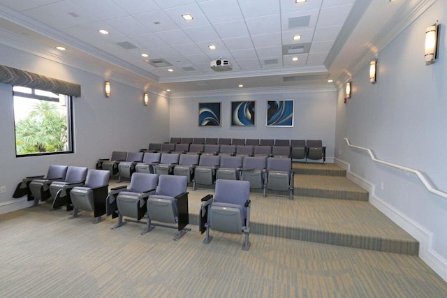 carpeted home theater with a raised ceiling and ornamental molding