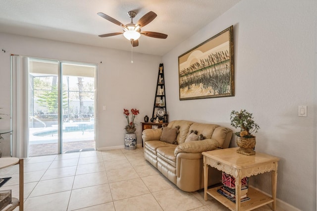 living room featuring light tile patterned flooring, ceiling fan, and a textured ceiling