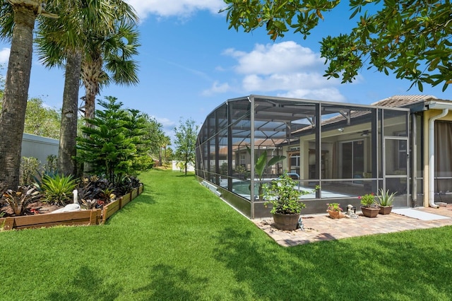 view of yard with glass enclosure and a patio