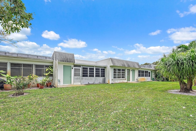 back of house featuring a sunroom and a yard