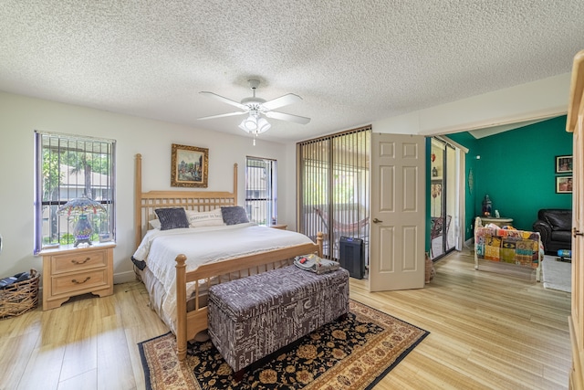 bedroom with light wood-style flooring, ceiling fan, and a textured ceiling