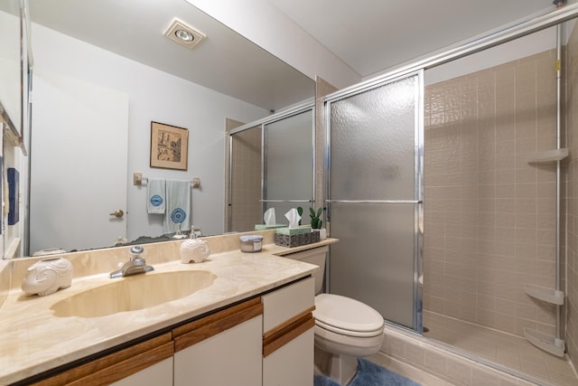 bathroom featuring toilet, a stall shower, and vanity