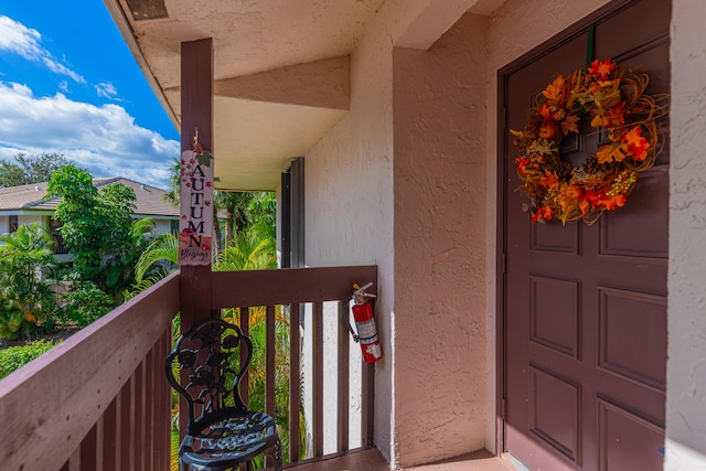 entrance to property with a balcony and stucco siding