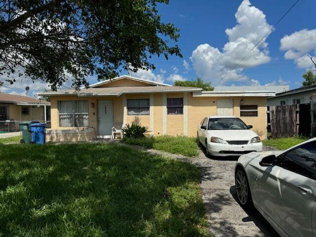 single story home featuring a front lawn