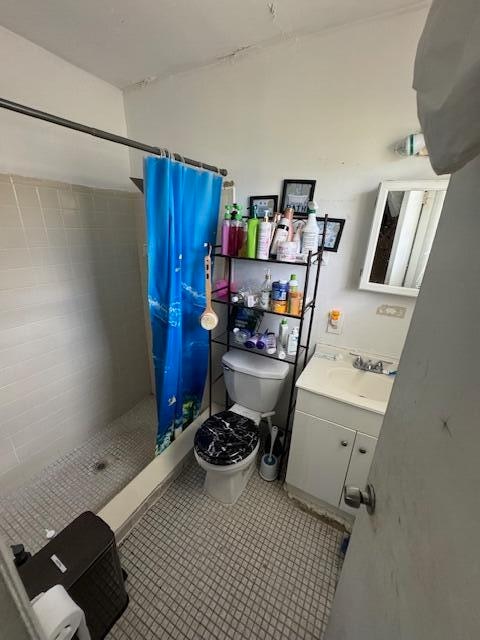 bathroom with toilet, vanity, and curtained shower