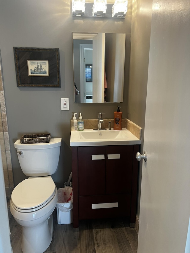 bathroom with vanity, wood-type flooring, and toilet