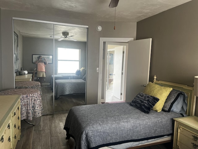 bedroom with dark hardwood / wood-style floors, a closet, and ceiling fan