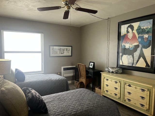 bedroom with a wall mounted air conditioner, ceiling fan, and dark wood-type flooring