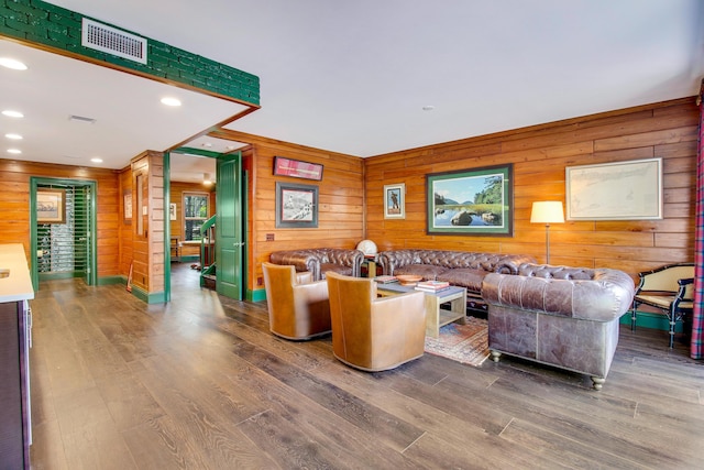 living room featuring hardwood / wood-style flooring and wooden walls