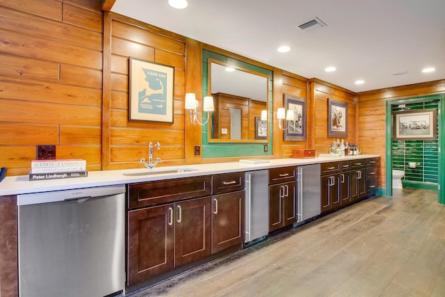 kitchen featuring dishwasher, sink, dark brown cabinets, and light wood-type flooring