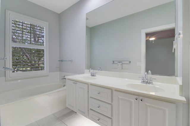 bathroom featuring tile patterned flooring, vanity, and a tub to relax in