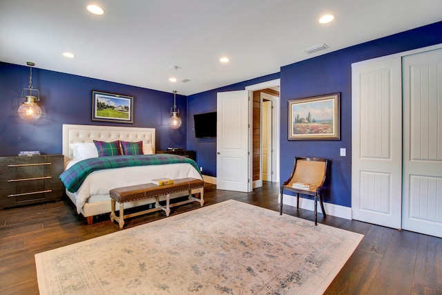 bedroom with dark wood-type flooring and a closet