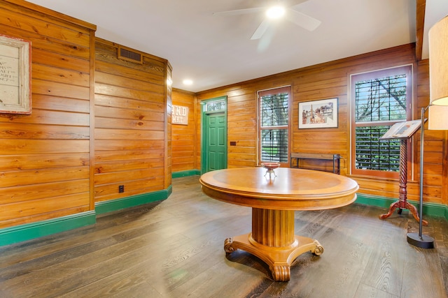 miscellaneous room with ceiling fan, a healthy amount of sunlight, wooden walls, and wood-type flooring