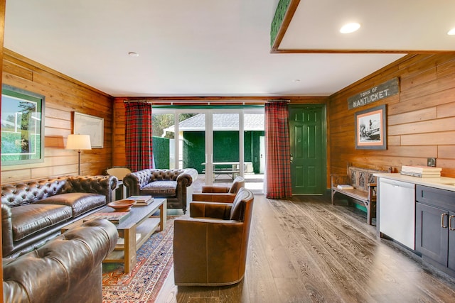 living room with dark hardwood / wood-style floors and wood walls