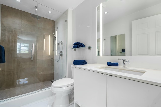 bathroom with vanity, toilet, and a shower with shower door