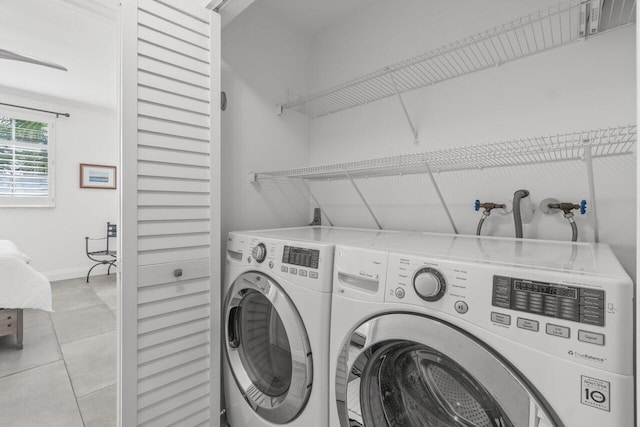 clothes washing area with washing machine and clothes dryer and light tile patterned floors