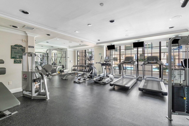 gym with crown molding and a raised ceiling