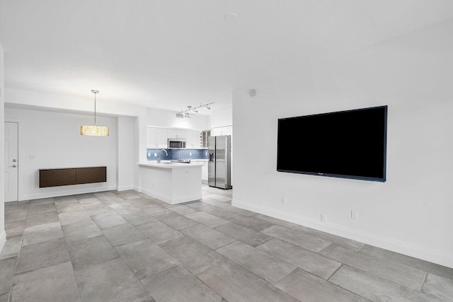 unfurnished living room with track lighting and sink