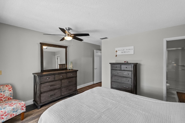 bedroom with ensuite bathroom, dark hardwood / wood-style flooring, a textured ceiling, and ceiling fan