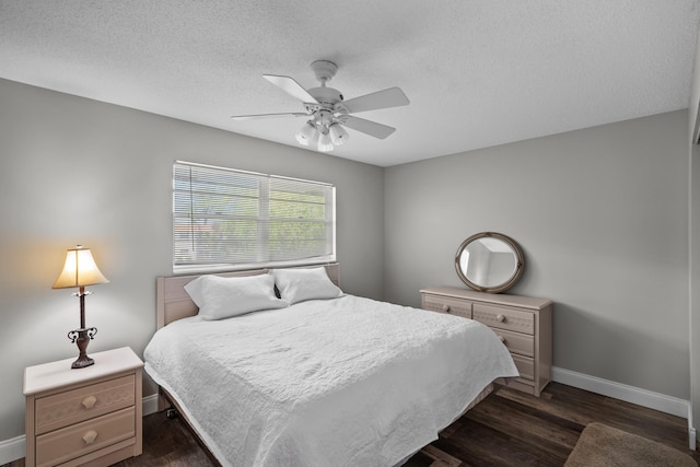 bedroom featuring a textured ceiling, dark wood-type flooring, and ceiling fan