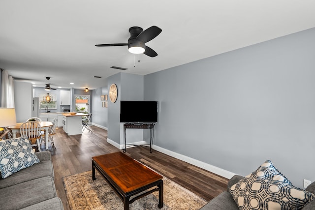 living room featuring hardwood / wood-style flooring, ceiling fan, and sink