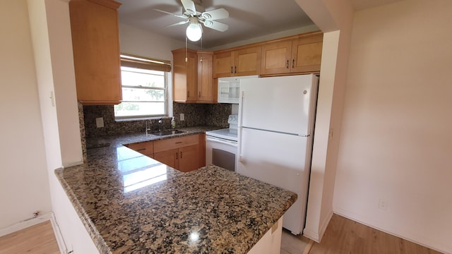 kitchen featuring white appliances, ceiling fan, kitchen peninsula, and tasteful backsplash