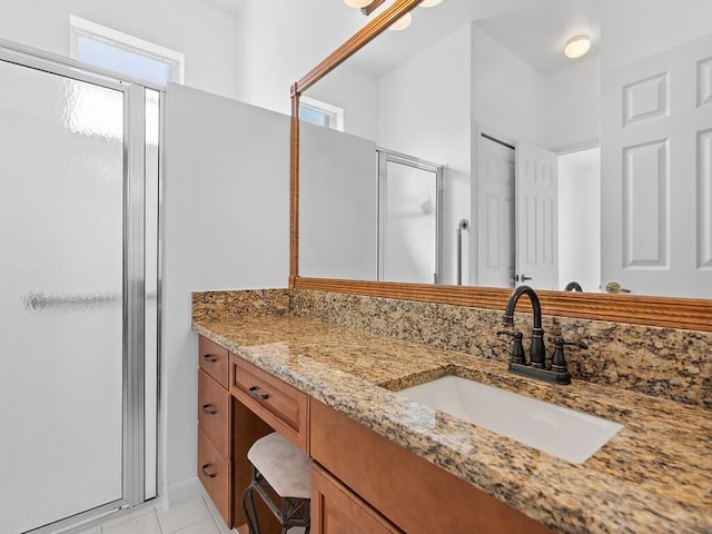 bathroom featuring tile patterned flooring, vanity, and a shower with shower door