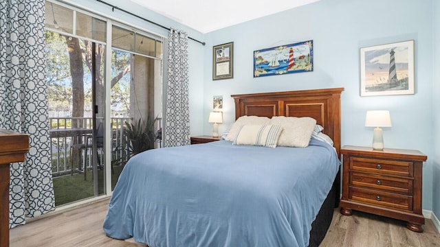 bedroom featuring light hardwood / wood-style floors, access to exterior, and multiple windows