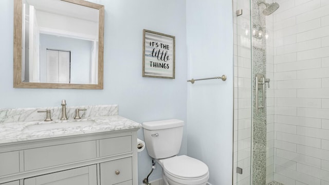 bathroom featuring toilet, vanity, and walk in shower