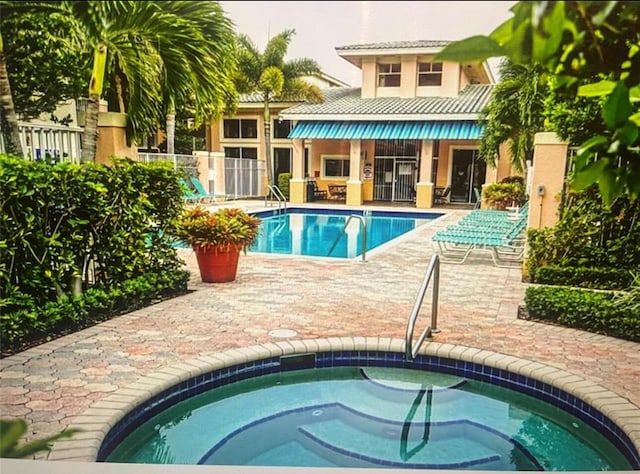 view of swimming pool with a patio area and a hot tub