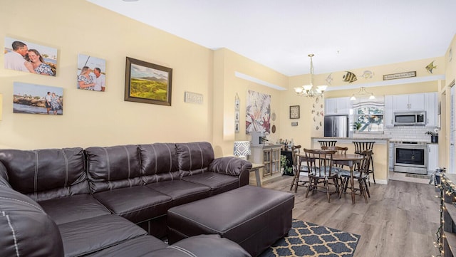 living room with a notable chandelier and light hardwood / wood-style floors