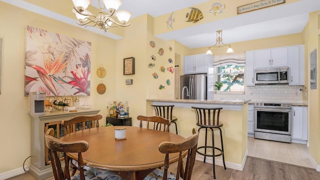 dining space with a chandelier and light hardwood / wood-style floors