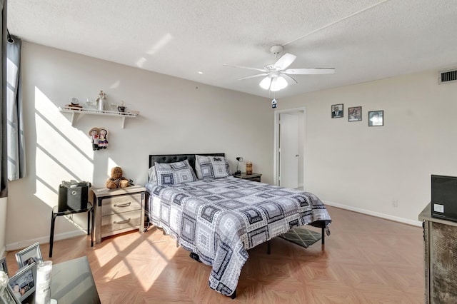 bedroom featuring ceiling fan, parquet flooring, and a textured ceiling