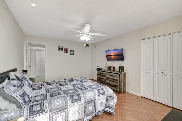 bedroom with ceiling fan, light parquet floors, a textured ceiling, and a closet